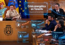 Crisis energética Tenerife: cuando la geopolítica entra por la cesta Imagen retocada del pleno del Cabildo de Tenerife con efectos holográficos sobre la crisis energética en Tenerife. La escena muestra a representantes institucionales en el salón de plenos, con gráficos luminosos superpuestos sobre combustibles, transporte y logística, agua y desalación, inflación, cesta de la compra y transición energética. La imagen relaciona el debate político insular con el impacto económico de Oriente Medio y la necesidad de reducir la dependencia del petróleo.
