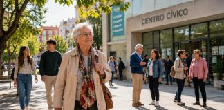 Envejecer con derechos: la deuda democrática con los mayores Persona mayor caminando con autonomía por una plaza luminosa junto a personas de distintas generaciones, con un centro cívico al fondo.