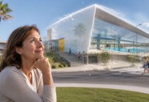 Piscina municipal Candelaria: adjudicado el contrato de obra Mujer de mediana edad observa con ilusión la futura piscina municipal de Candelaria, representada como una infraestructura moderna y luminosa.