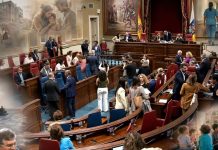 Pleno canario de junio: datos frente a la vida real Salón de plenos del Parlamento de Canarias con alusiones difuminadas a la vivienda, la sanidad, la infancia, la migración y la educación.