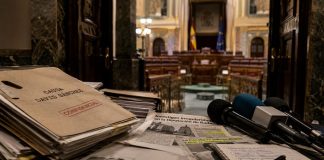 Condena de David Sánchez: justicia, política y lawfare Expedientes judiciales, recortes de prensa y micrófonos ante una sala institucional, como símbolo de la tensión entre justicia, medios y confrontación política.