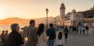 2 de febrero: firma para proteger la memoria de Candelaria Familias de varias generaciones caminan al atardecer hacia la Basílica de Candelaria, junto al mar, algunas con velas encendidas.