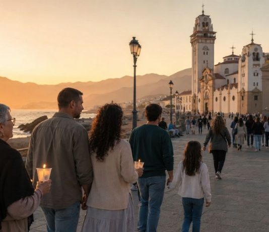 2 de febrero: firma para proteger la memoria de Candelaria Familias de varias generaciones caminan al atardecer hacia la Basílica de Candelaria, junto al mar, algunas con velas encendidas.