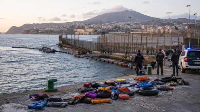 Frontera marítima de Ceuta con agentes de seguridad, embarcaciones de vigilancia y flotadores abandonados tras la entrada masiva desde Marruecos.