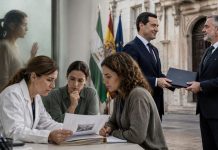 Vox y violencia machista: la cesión de Juanma Moreno Juanma Moreno entrega una carpeta institucional a Manuel Gavira mientras un equipo de profesionales atiende un caso de violencia machista.
