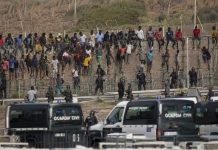Devoluciones masivas en Ceuta: los límites de la ley Migrantes junto a la valla fronteriza de Ceuta bajo vigilancia de la Guardia Civil durante una situación de fuerte presión migratoria.