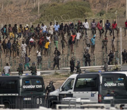 Devoluciones masivas en Ceuta: los límites de la ley Migrantes junto a la valla fronteriza de Ceuta bajo vigilancia de la Guardia Civil durante una situación de fuerte presión migratoria.