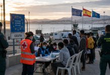 Política migratoria democrática: la salida para Ceuta Frontera de Ceuta con agentes de la Guardia Civil y personal humanitario atendiendo e identificando a personas migrantes junto al puerto.
