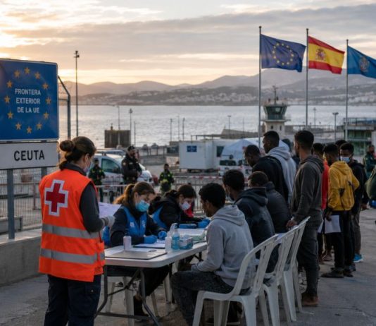 Política migratoria democrática: la salida para Ceuta Frontera de Ceuta con agentes de la Guardia Civil y personal humanitario atendiendo e identificando a personas migrantes junto al puerto.
