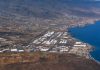 Vertidos de Güímar: la historia empezó antes de los alcaldes Vista aérea del Polígono Industrial del Valle de Güímar junto a la costa de Tenerife, con el océano, las naves industriales y el relieve del valle al fondo.