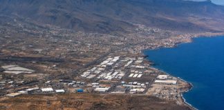 Vertidos de Güímar: la historia empezó antes de los alcaldes Vista aérea del Polígono Industrial del Valle de Güímar junto a la costa de Tenerife, con el océano, las naves industriales y el relieve del valle al fondo.