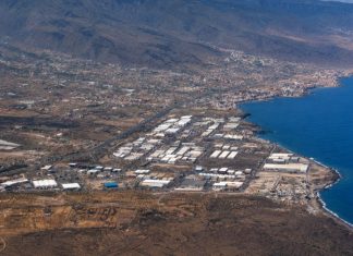 Vertidos de Güímar: la historia empezó antes de los alcaldes Vista aérea del Polígono Industrial del Valle de Güímar junto a la costa de Tenerife, con el océano, las naves industriales y el relieve del valle al fondo.