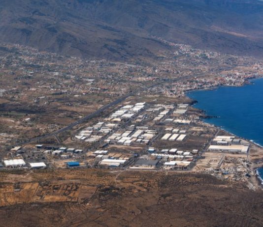 Vertidos de Güímar: la historia empezó antes de los alcaldes Vista aérea del Polígono Industrial del Valle de Güímar junto a la costa de Tenerife, con el océano, las naves industriales y el relieve del valle al fondo.
