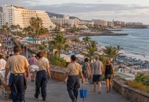 Prosperidad turística canaria: ¿quién gana realmente? Zona turística costera de Canarias con hoteles, playas, visitantes y trabajadores del sector, reflejo del contraste entre actividad turística y vida cotidiana.