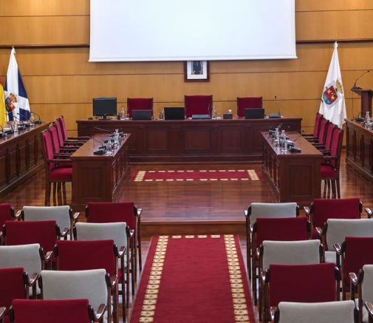 Pleno de Candelaria: gestión, cuentas y proyectos Sala de plenos del Ayuntamiento de Candelaria vacía, con las mesas de los concejales, la presidencia, las banderas institucionales y las butacas del público.