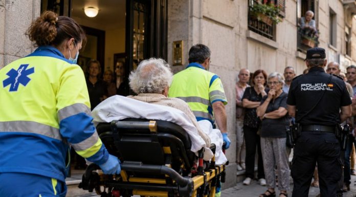 Desahucio de Maricarmen: la legalidad de un fracaso Mujer mayor sale en camilla de un edificio de Madrid acompañada por sanitarios, con vecinos y Policía Nacional durante un desahucio.