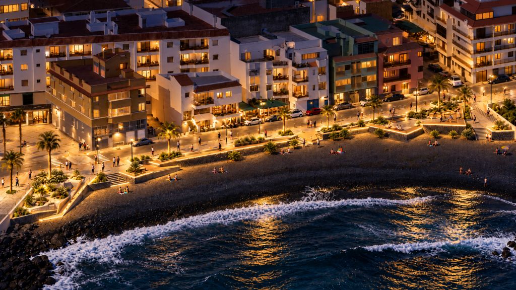 Recreación al atardecer del futuro paseo de la playa de Olegario, con iluminación cálida, plataformas de descanso y vegetación junto al mar.