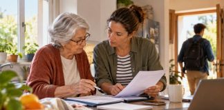 Pensiones públicas: ¿quiebra real o alarmismo? Una mujer jubilada y otra de mediana edad revisan documentos económicos en la cocina de una vivienda, mientras un joven sale hacia el trabajo al fondo.