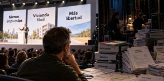 Soluciones fáciles en política: ¿por qué nos convencen? Un ciudadano observa un mitin con promesas políticas sencillas mientras, entre bastidores, se acumulan documentos que representan los costes y la complejidad de las decisiones públicas.